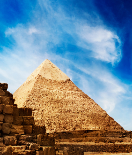 Great Pyramid of Giza under a bright blue sky, with foreground blocks of ancient stone - Aufgang Travel
