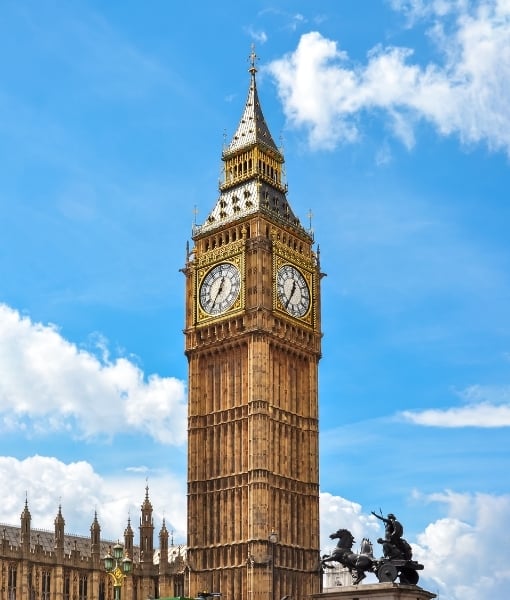 Iconic Big Ben clock tower (Elizabeth Tower) at the Palace of Westminster under a blue sky, with ornate detailing visible on the façade. - Aufgang Travel
