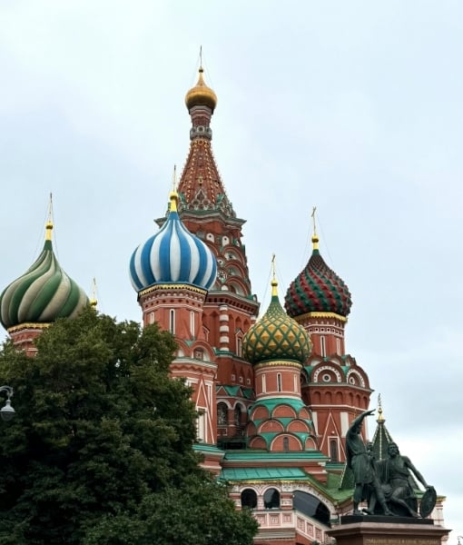 Saint Basil's Cathedral in Moscow with colorful onion domes and a statue in the foreground. - Aufgang Travel